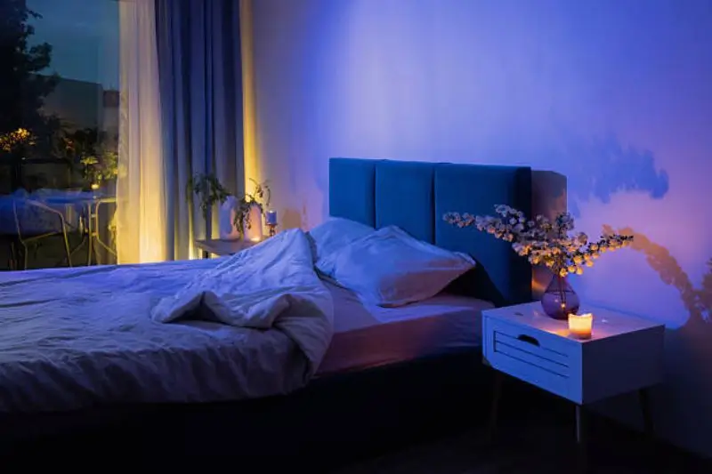 LED strip lighting behind headboard in small mens bedroom