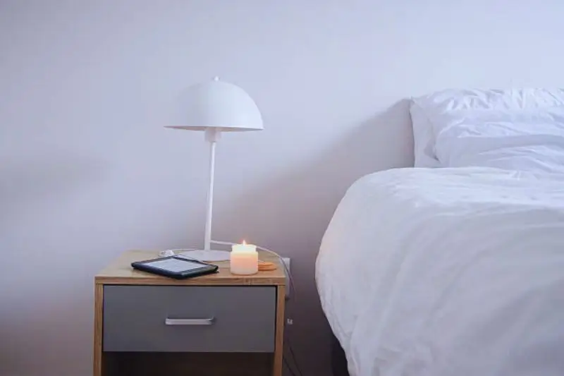 bedside charging shelf with candle in small mens bedroom