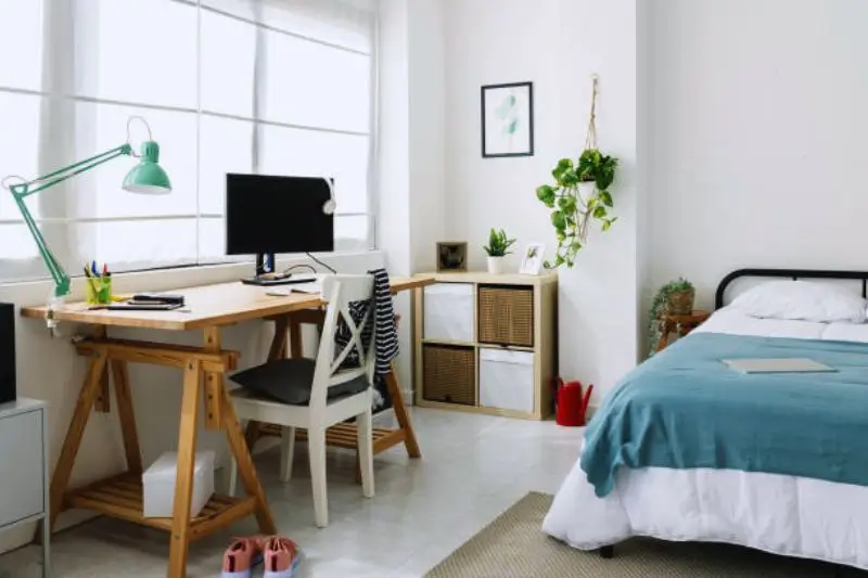 corner desk with laptop in small mens bedroom