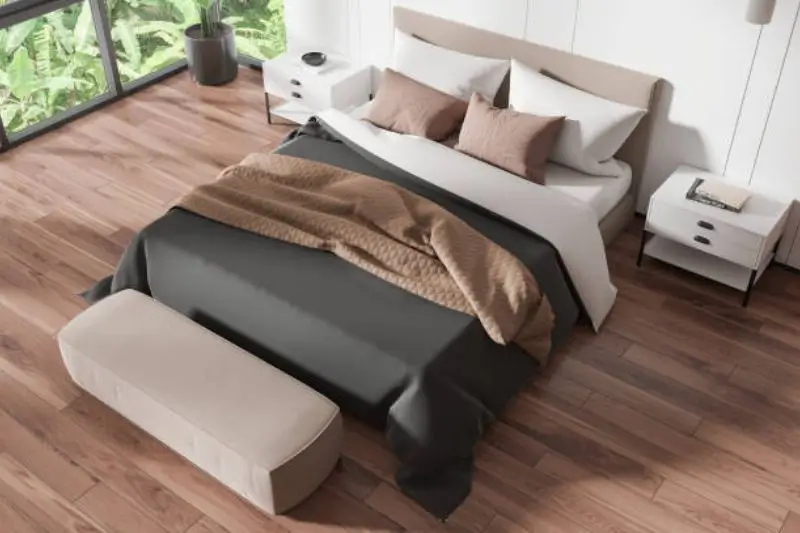 dark leather storage ottoman at foot of bed in small bedroom