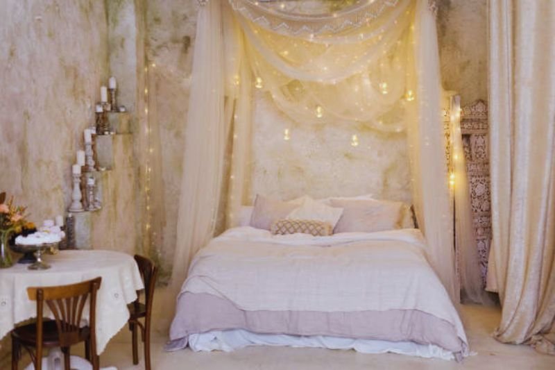 fairy lights behind sheer curtain on wall in small bedroom