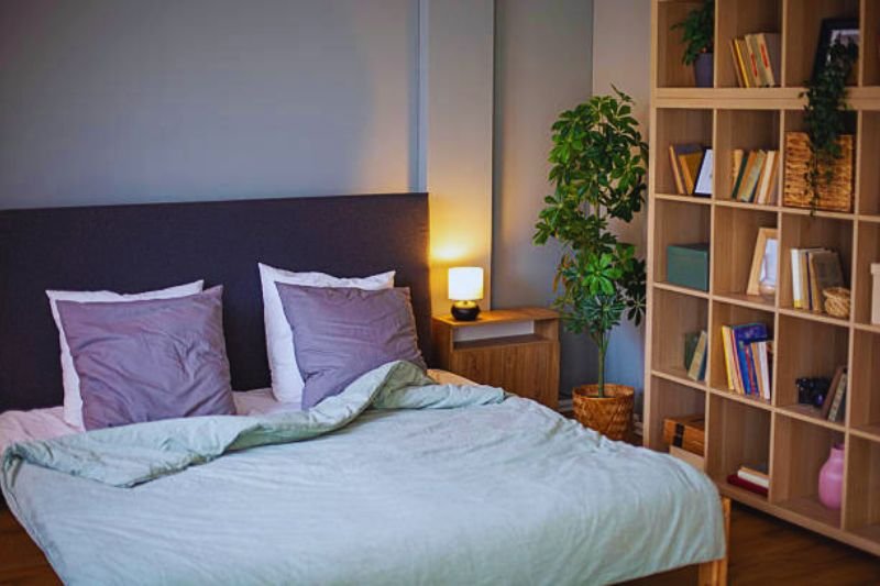 floating shelves with books and decor in small mens bedroom