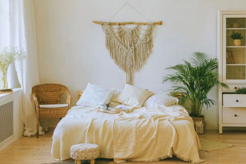 macrame wall hanging above bed in small bedroom