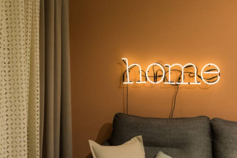small LED word sign on wall in small bedroom