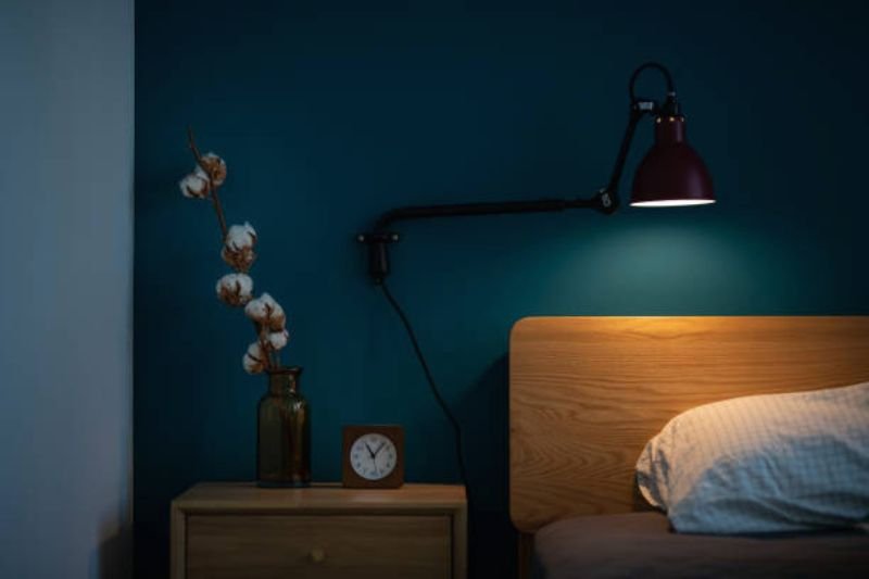 swing arm reading light above bed in small bedroom
