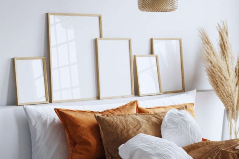 vertical gallery wall with stacked frames in small bedroom
