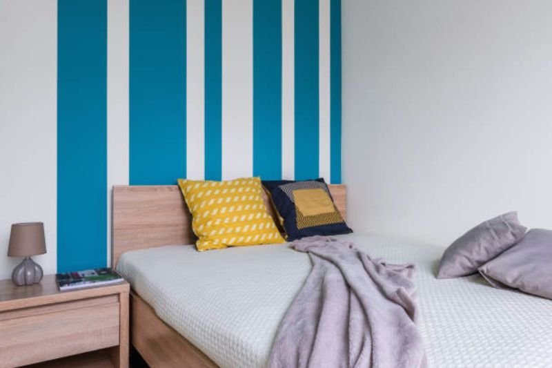 vertical painted stripes on wall in small bedroom