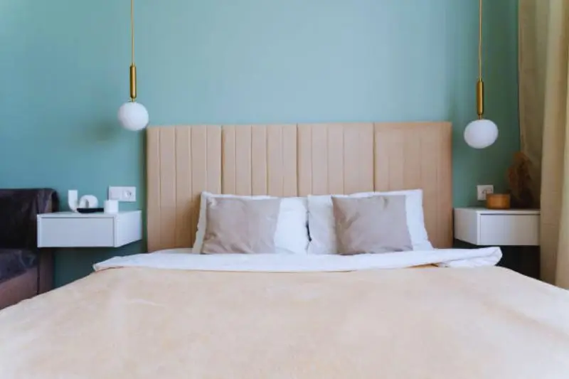 brass swing arm wall sconces above nightstands in small bedroom
