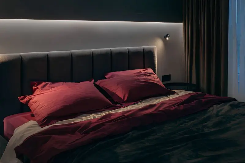 LED strip lighting behind headboard in small couples bedroom