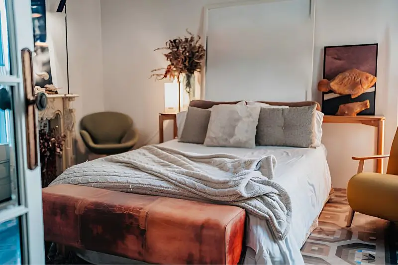 upholstered bench at foot of bed in small couples bedroom