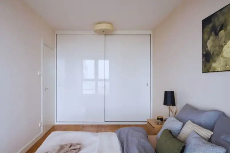floor to ceiling wardrobe with sliding doors in small bedroom