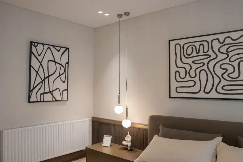sculptural pendant light hanging in small couples bedroom