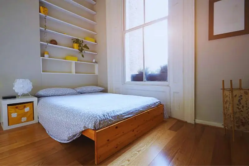 leggy furniture with visible floor in small couples bedroom