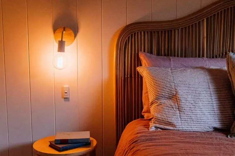 fluted wood paneling behind bed in small couples bedroom