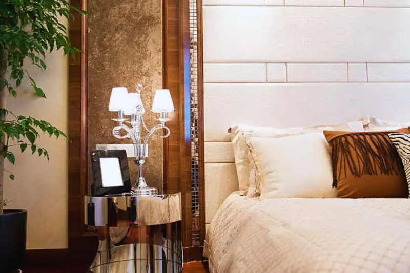 mirrored nightstand reflecting light in small couples bedroom