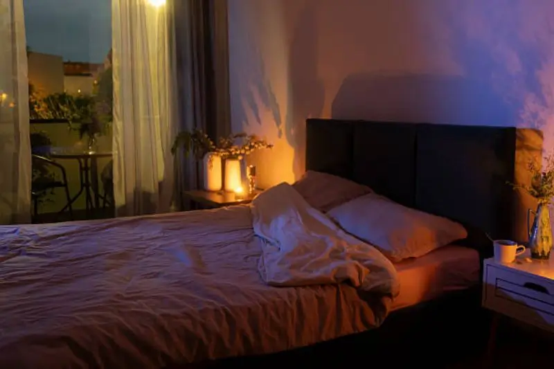 warm dimmed lamps and sconces in small couples bedroom