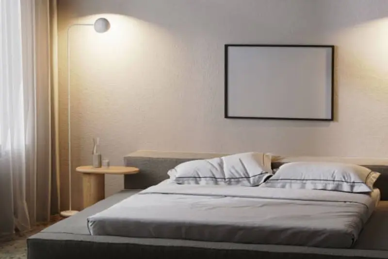 brass picture light over framed art above bed in small bedroom