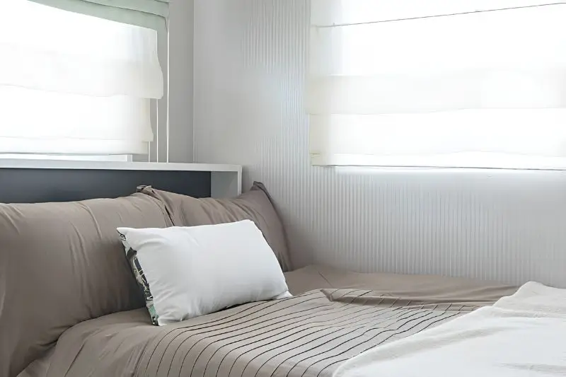 linen roman shades on window in small couples bedroom