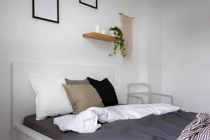 floating wood shelves with decor in small couples bedroom