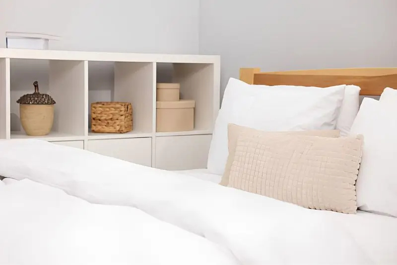 matching lidded storage bins under raised bed in small bedroom